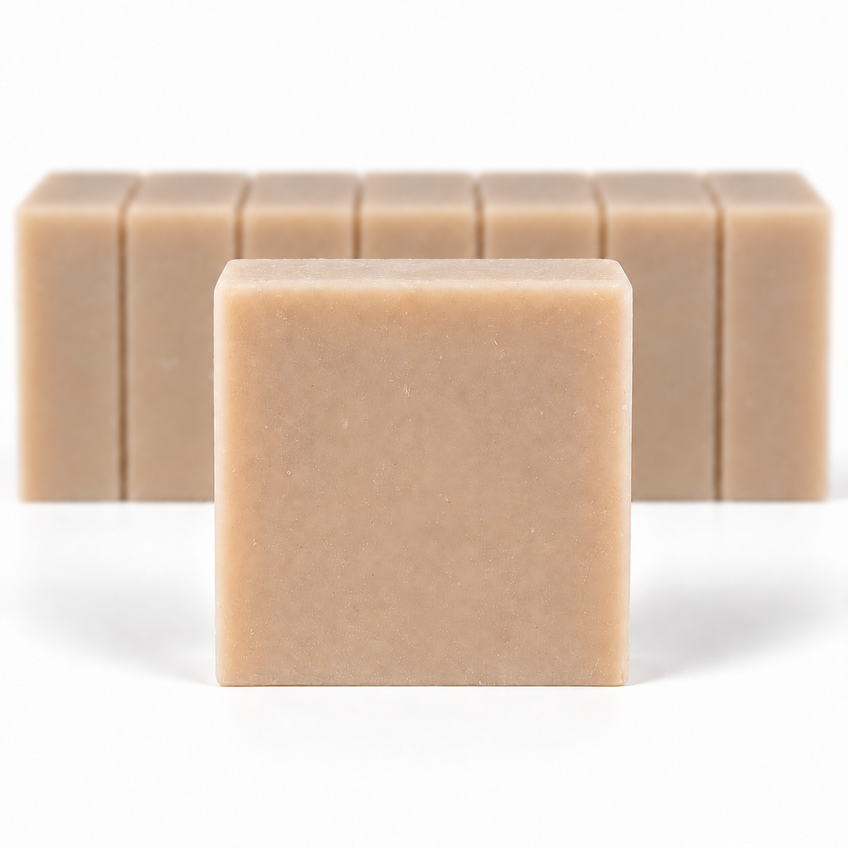Almond Coconut Soap, with a sharp foreground soap bar and a softly blurred row of bars on a white background.