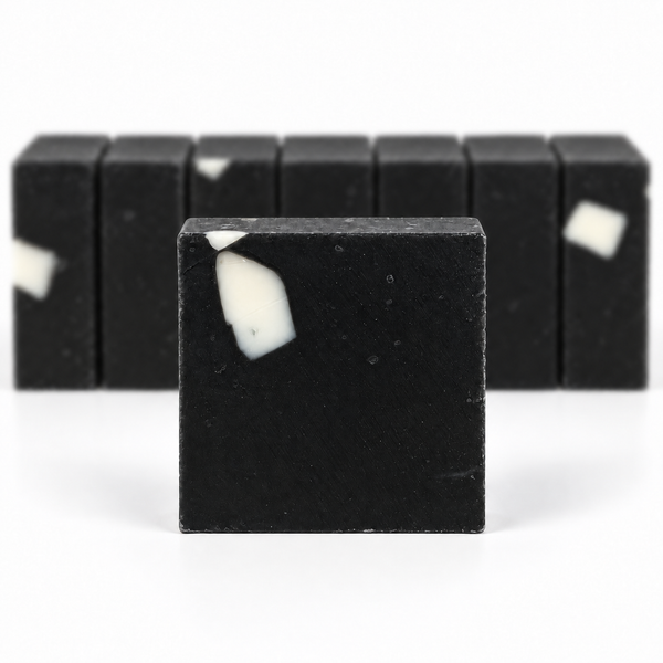 Charcoal Aloe Soap, with a sharp foreground soap bar and a softly blurred row of bars on a white background.