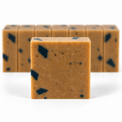 Dead Sea Mud, with a sharp foreground soap bar and a softly blurred row of bars on a white background.
