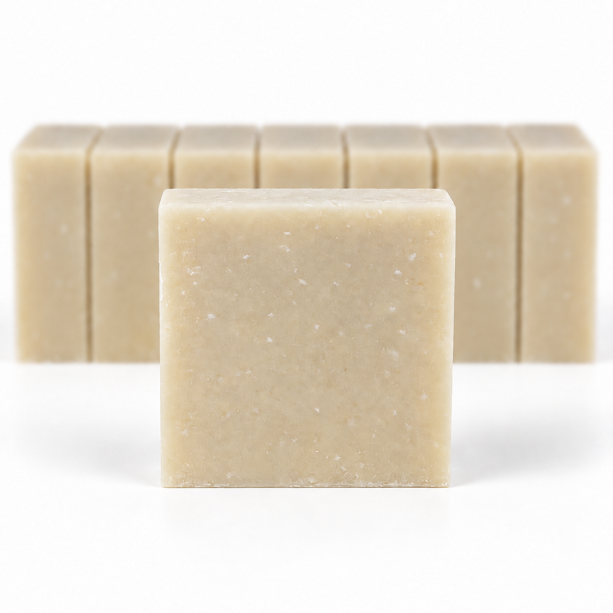 Milk and Collagen with Goat's Milk, with a sharp foreground soap bar and a softly blurred row of bars on a white background.